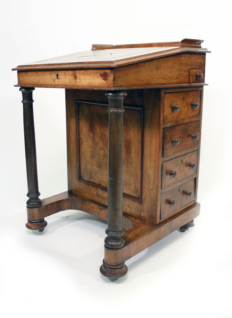 WITHDRAWN  An early Victorian figured walnut Davenport of typical form, the hinged top on columnar