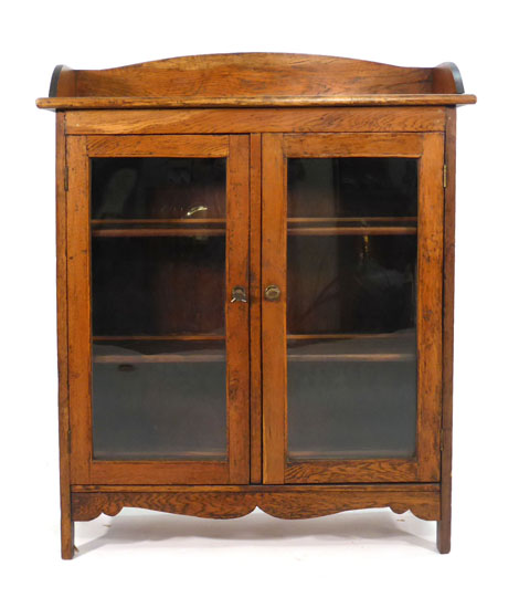 An early 20th century oak bookcase with three quarter gallery over a pair of glazed doors, w. 102 cm