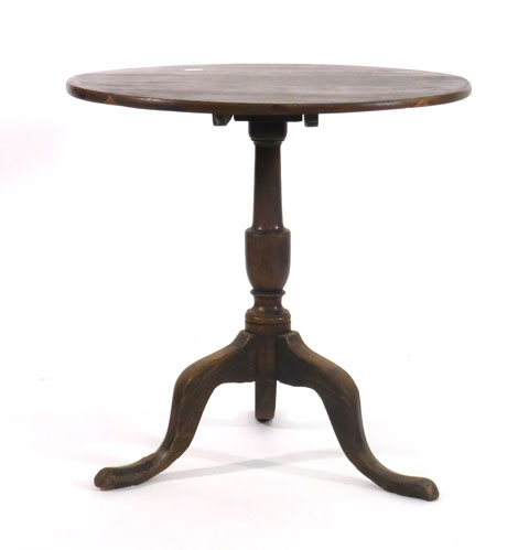 An 18th century oak supper table with circular tilting top on a vase turned support with tripod