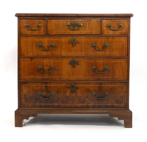 An 18th century and later walnut, strung, crossbanded and quarter veneered chest of three