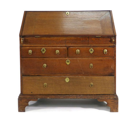 An early 18th century oak bureau, the fall front revealing a fitted interior with well, over two