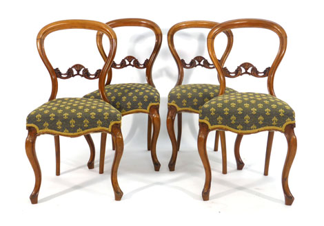 A set of four Victorian walnut framed dining chairs with moulded balloon backs on cabriole legs