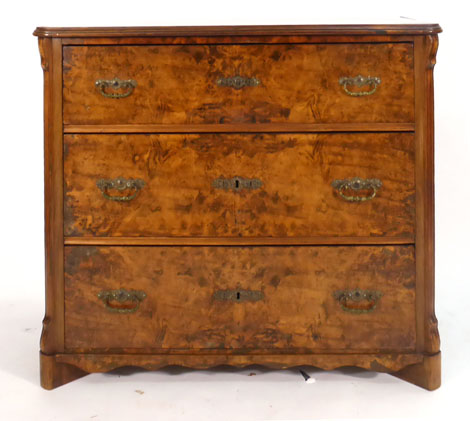 A 19th century Continental figured walnut chest of three long drawers with canted stiles on block