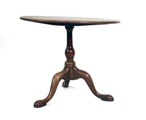 A mid-18th century mahogany circular tilt-top table on a slender baluster turned support with tripod