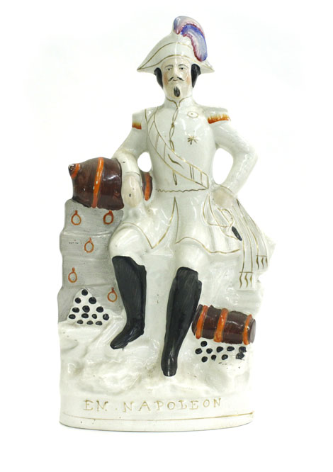 A titled figure of Napoleon III perched on a gun emplacement, inscribed, predominantly white, h.