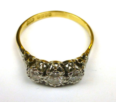 An 18ct yellow gold ring set three graduated diamonds in an illusion setting, ring size P/Q