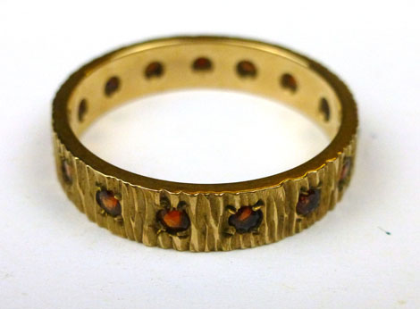 A 9ct yellow gold band ring set garnets, ring size N/O