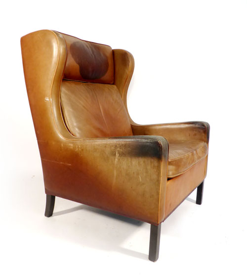 A brown leather wingback armchair on straight mahogany legs, in the manner or Borge Morgensen