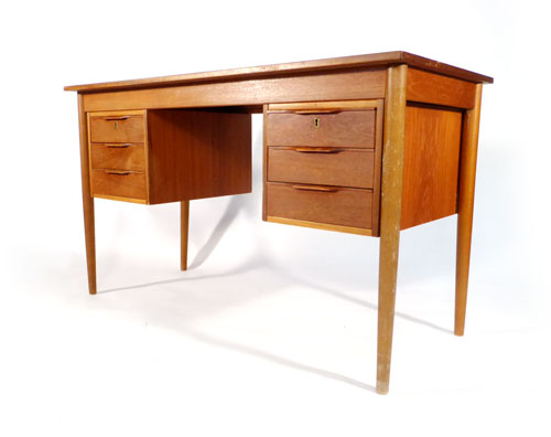 A Danish teak desk on four tapering legs with two three drawer pedestals suspended below, l. 121 cm