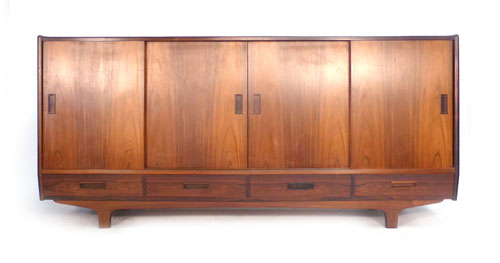 A 1960s Brazilian rosewood Danish highboard, the four sliding doors revealing fitted drawers and a