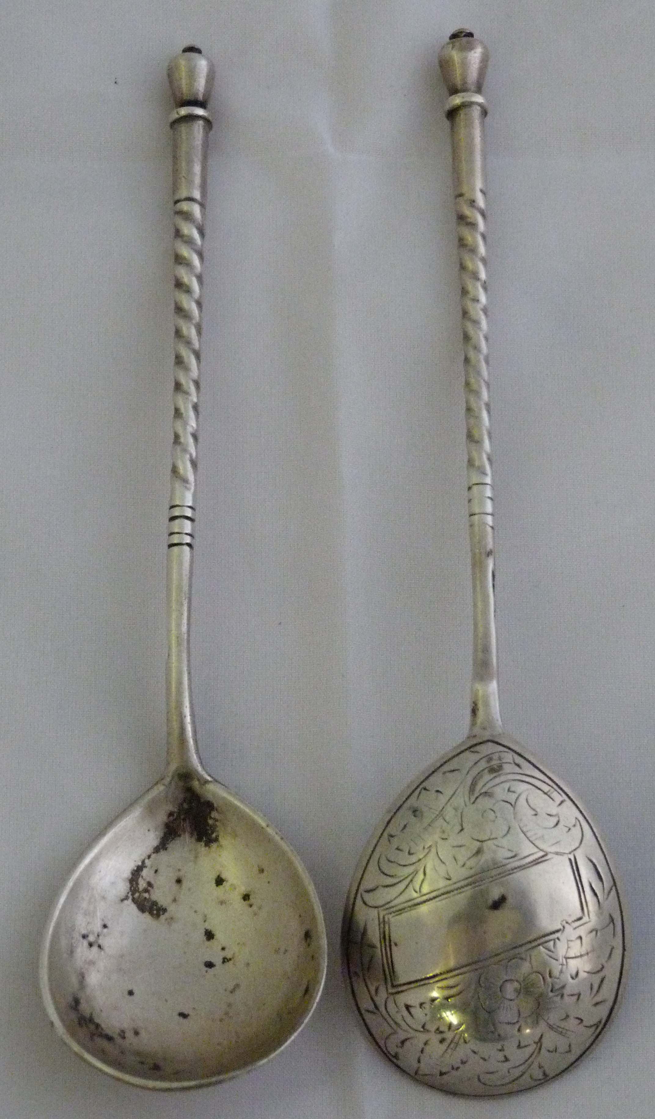 A pair of Russian silver spoons having chased decorated bowls, surrounding a rectangular vacant