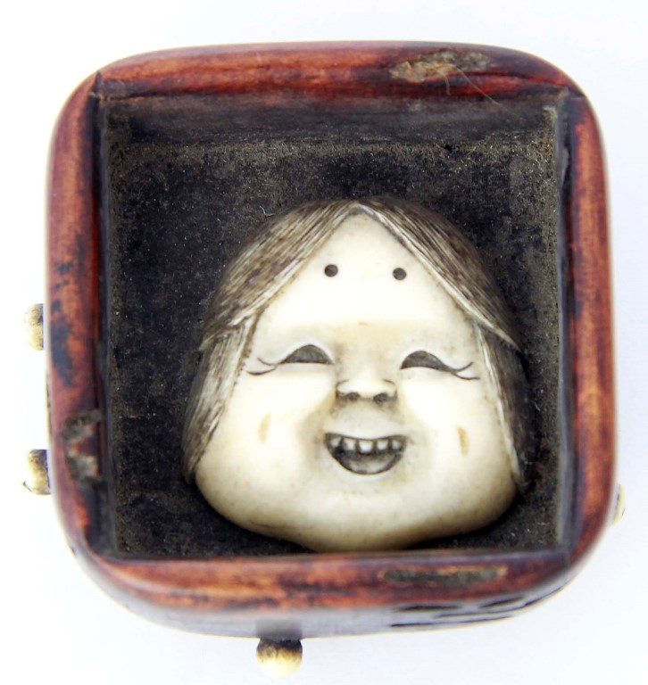 A Japanese boxwood and ivory netsuke depicting Kyogen (comic mask) of Hyottoka, probably Meiji