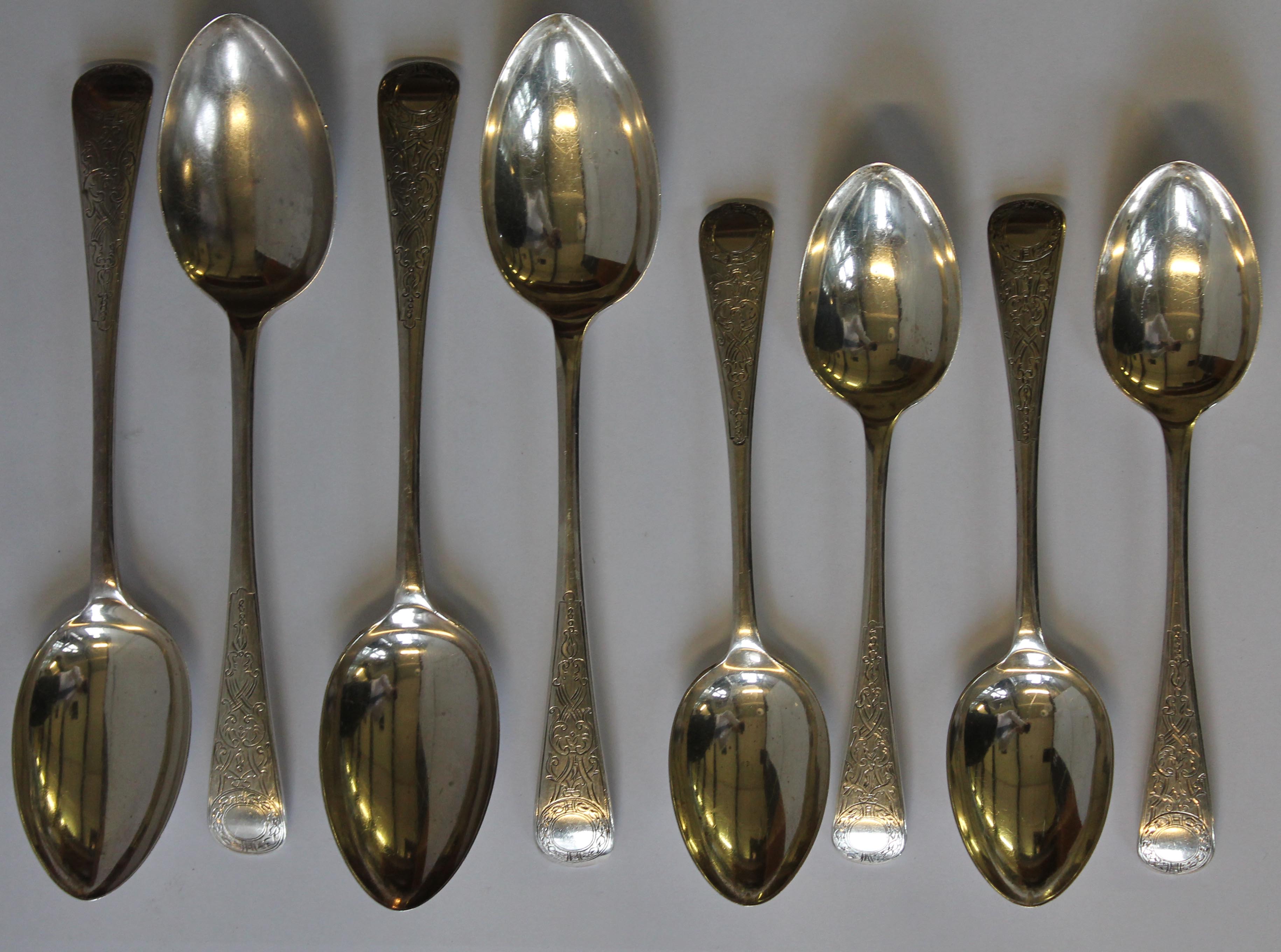 An Edward VII hallmarked silver set of four table and four dessert spoons, each having chased