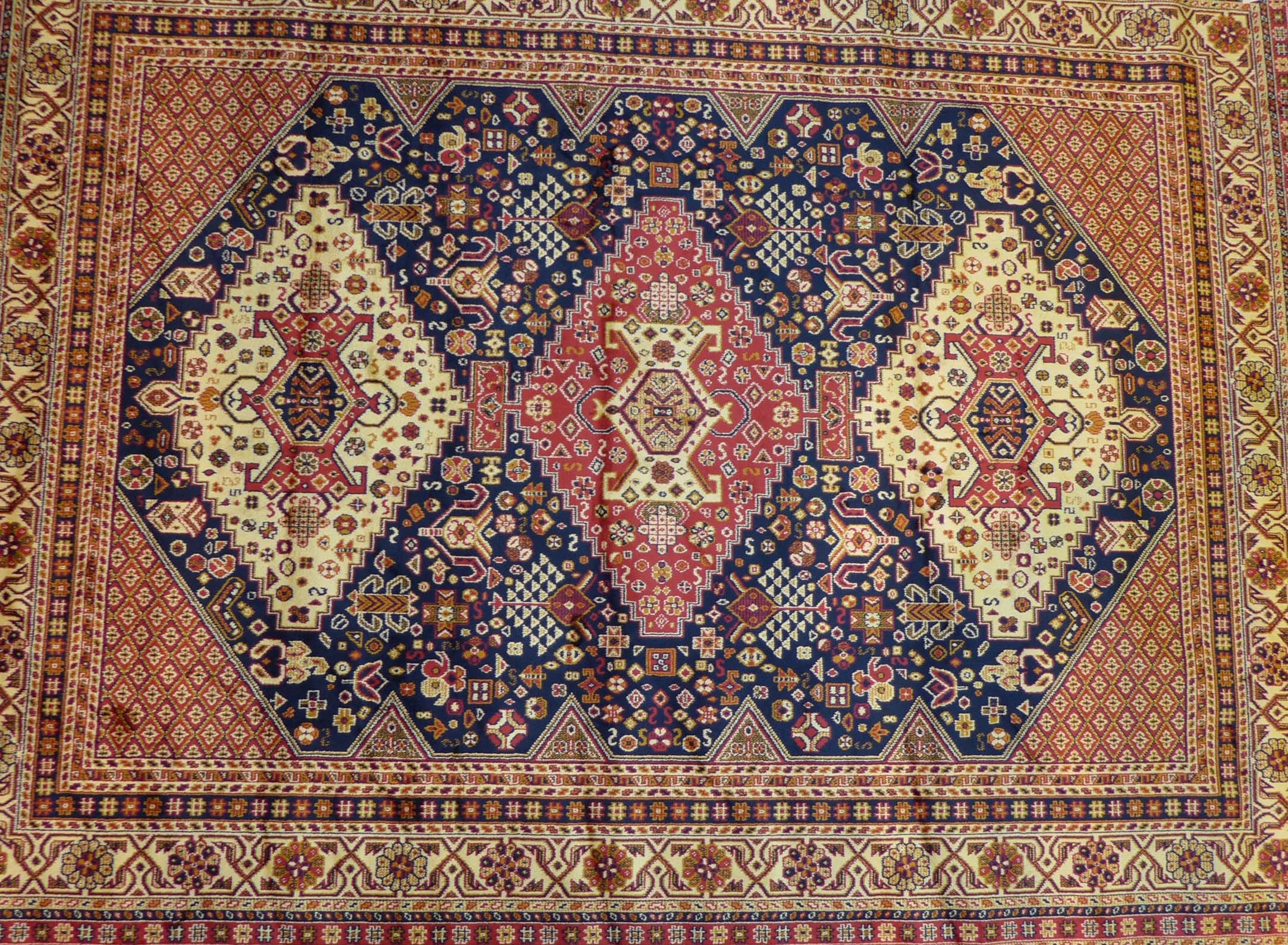 A Caucasian rug, on a mainly blue ground, the central panel with three multicoloured medallions,