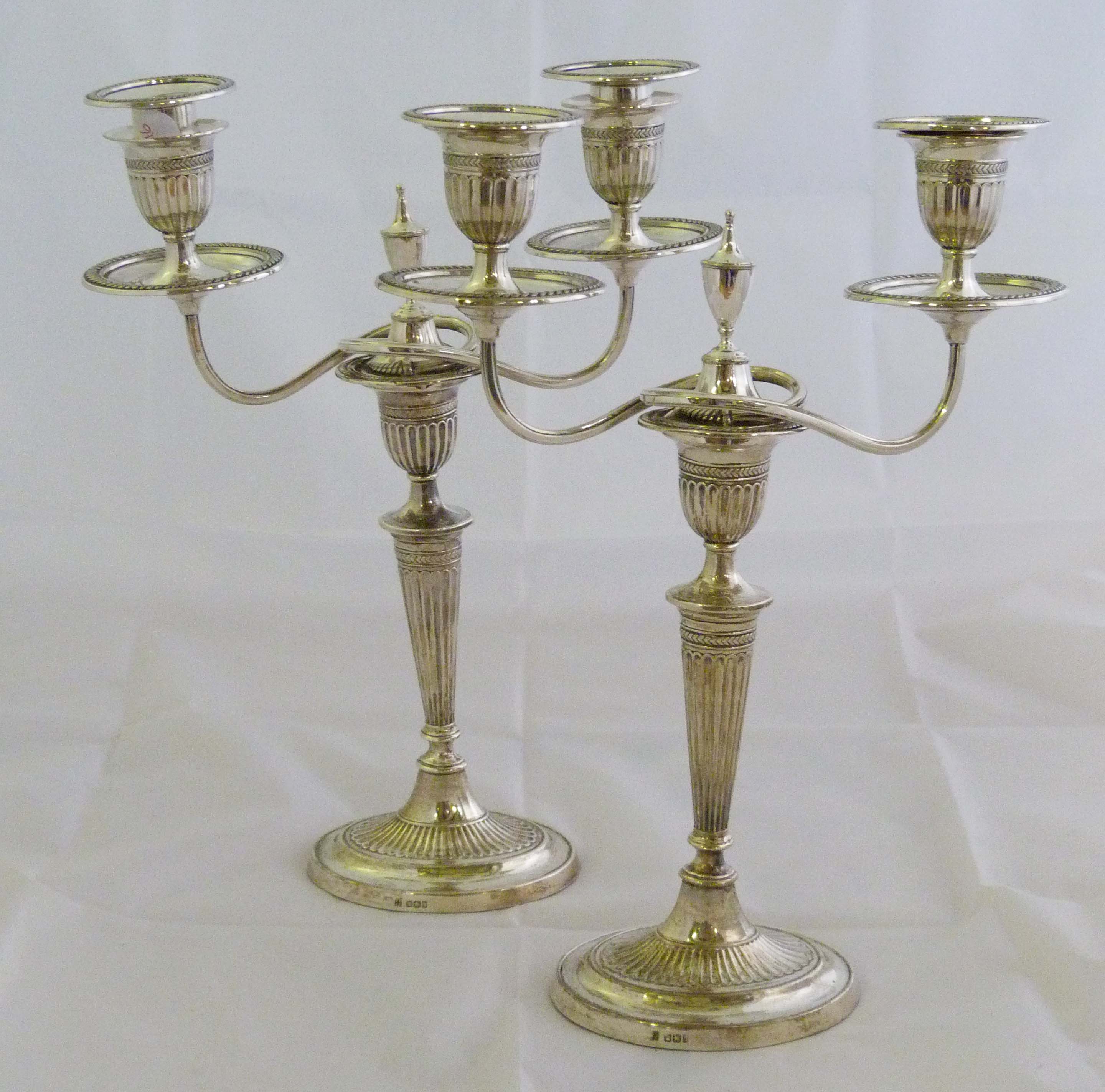 A pair of late Victorian hallmarked silver two branch candelabra with detachable arms, with later