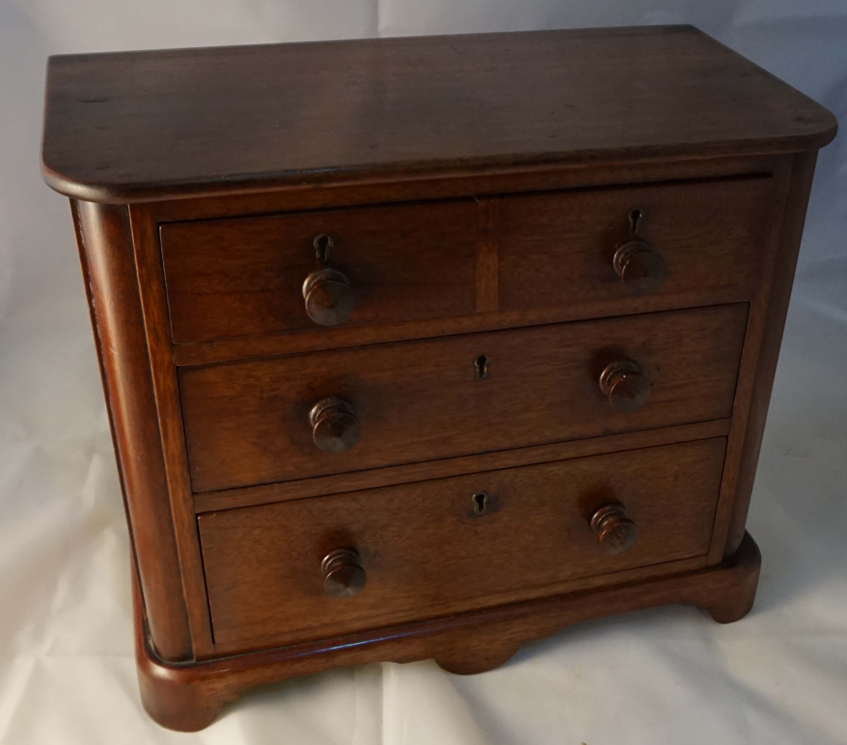 A Victorian mahogany apprentice chest of drawers, having three single drawers, raised on bracket