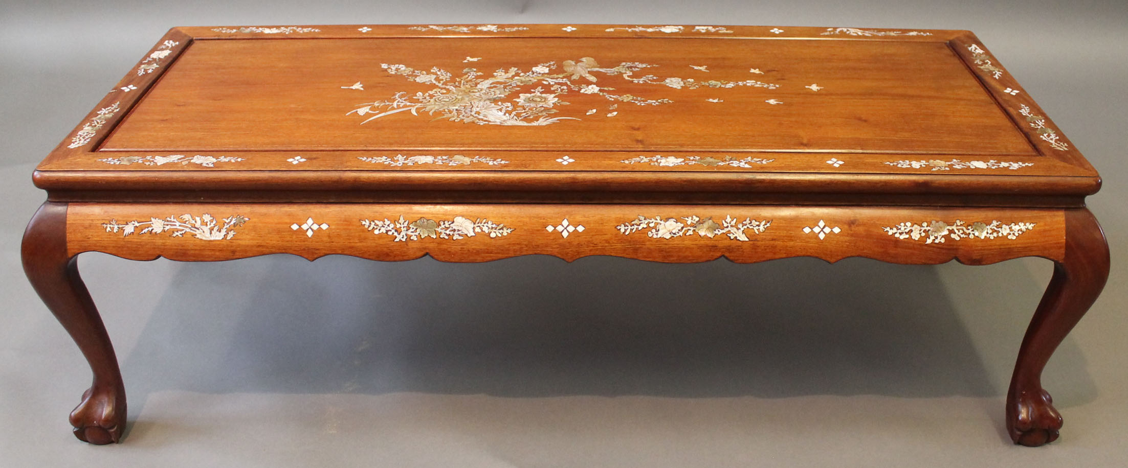 A Chinese hardwood low 'Kang' table, 20th century, the single plank top inset with recessed panels