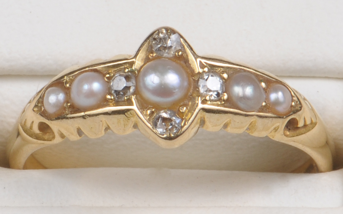 A late 19th century 18ct seed pearl and diamond set dress ring, the central seed pearl with tiny old