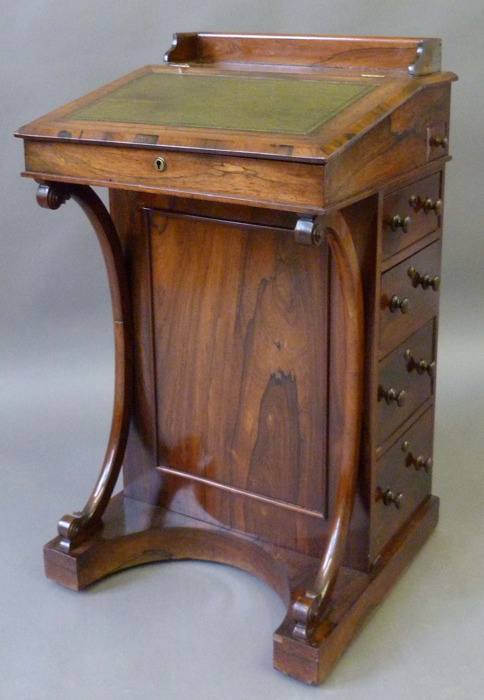 A Victorian rosewood Davenport, featuring a three quarter gallery back above the hinged slope with