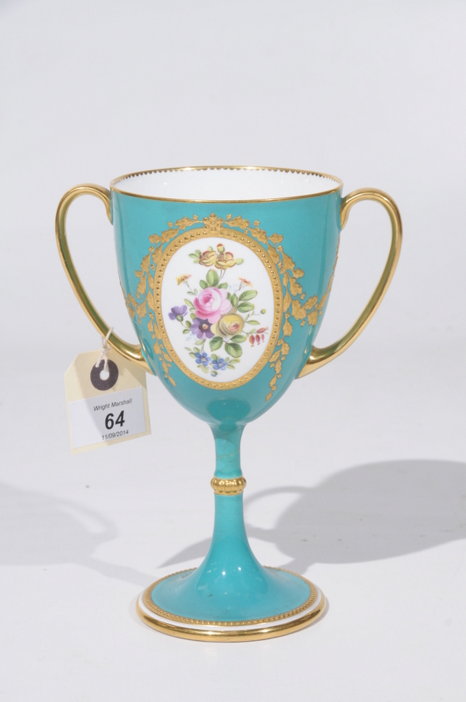 A MINTON TWO HANDLED LOVING CUP, the green ground painted with ovals depicting roses and other