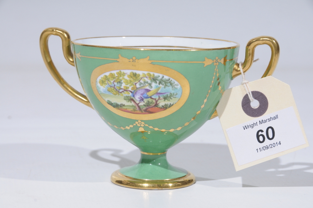 A MINTON TWO HANDLED CABINET CUP, green ground with gilt framed ovals painted with a bird perched