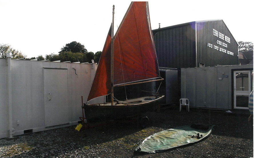 A CORNISH COVE SAILING DINGHY, 13` gaffe rigged with trailer, cover and original sails rudder in