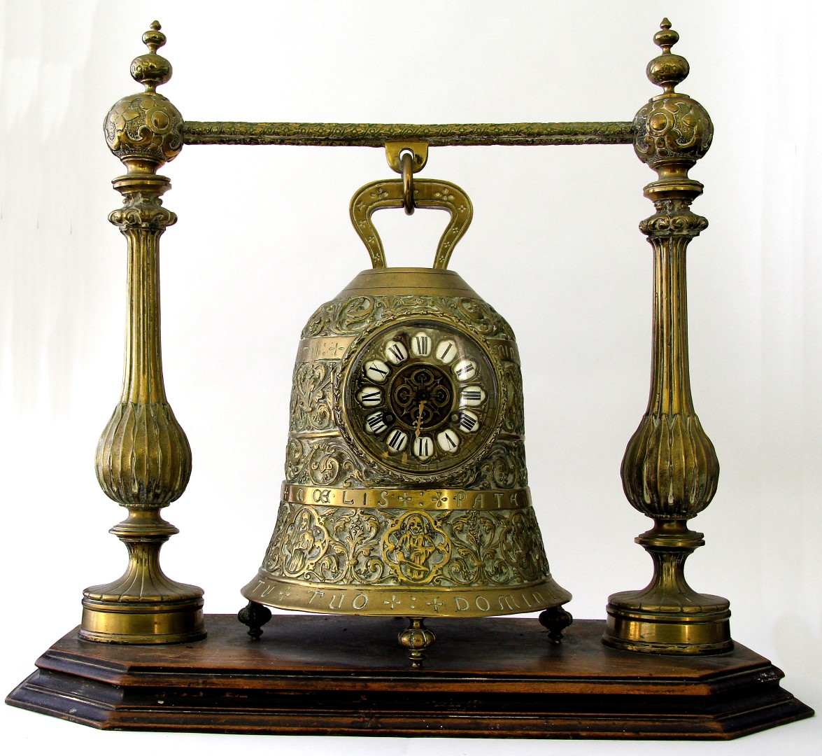 An unusual brass bell mantel clock with a 10cm brass dial with Roman numerals within cartouches, the