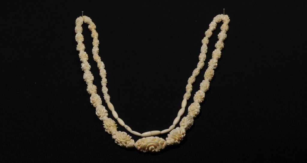 A GRADUATED CARVED IVORY BEAD NECKLACE, Oval beads with deep foliate carving. Small screw thread