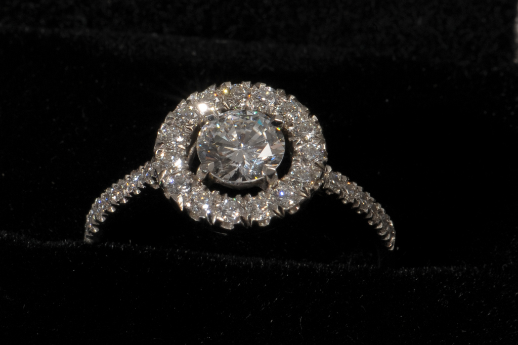 A MODERN DIAMOND CLUSTER RING, Central claw set single brilliant cut claw estimated to weigh 0.