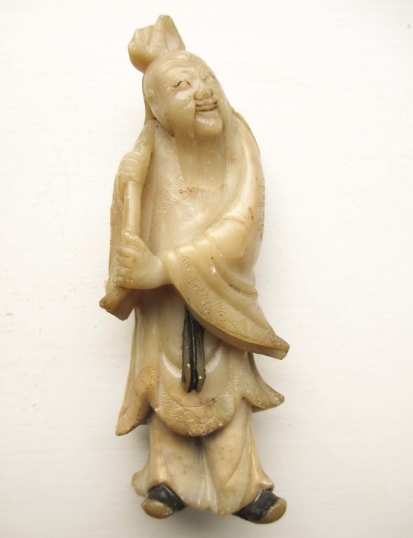 A carved God figure carrying a staff. Some wear and loses. Approx 5 inches tall.