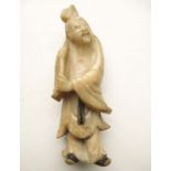 A carved God figure carrying a staff. Some wear and loses. Approx 5 inches tall.