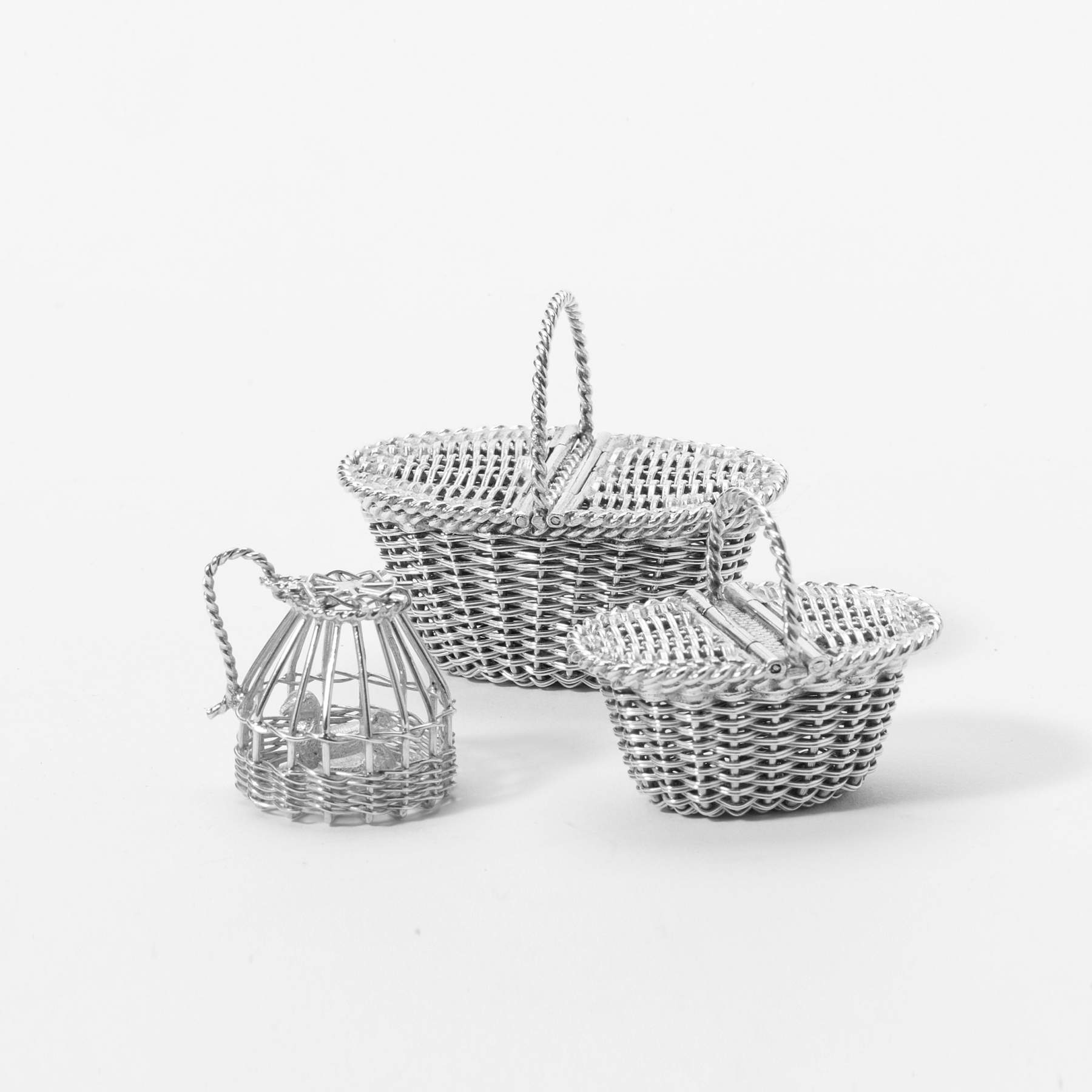 A  miniature silver basket with two ducks and two oval miniature shopping baskets of woven silver
