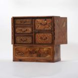 A cabinet with drawers inlaid with various types of wood