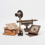 A theodolite, a table compass, a condenser lens, a box with specimens, two pocket telescopes and
