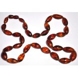 An amber coloured oval bead necklace, le