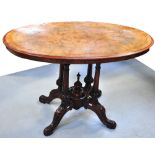 A Victorian walnut oval centre table with marquetry inlay, the four column supports extending to