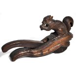 A late Victorian novelty carved beech nutcracker modelled as a squirrel nibbling his nuts, length