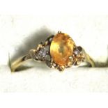 A 9ct gold ring, the central oval orange