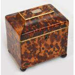 An early 19th century tortoiseshell tea caddy, the pagoda hinged top set with a white metal plaque