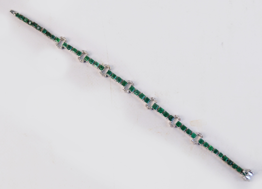 A white metal emerald and diamond bracel