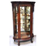 An early 20th century oak display cabinet with bow front glass door and convex glass sides, four