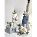 Four Nao figures, an angelic girl, two cats in a basket, a cat and dog and a lamp in the form of a