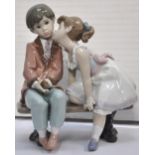 A signed Lladro anniversary piece, a boy and a girl kissing.