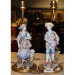 A pair of late 19th century Continental porcelain figures of a gent and a lady, now both mounted on