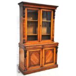 A large Victorian oak bookcase on cupboard, the moulded cornice above an upper section with two