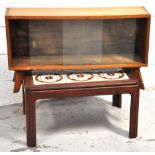 A 1970s light oak glazed bookcase on outsplayed legs, width 90cm, together with a retro tiled top