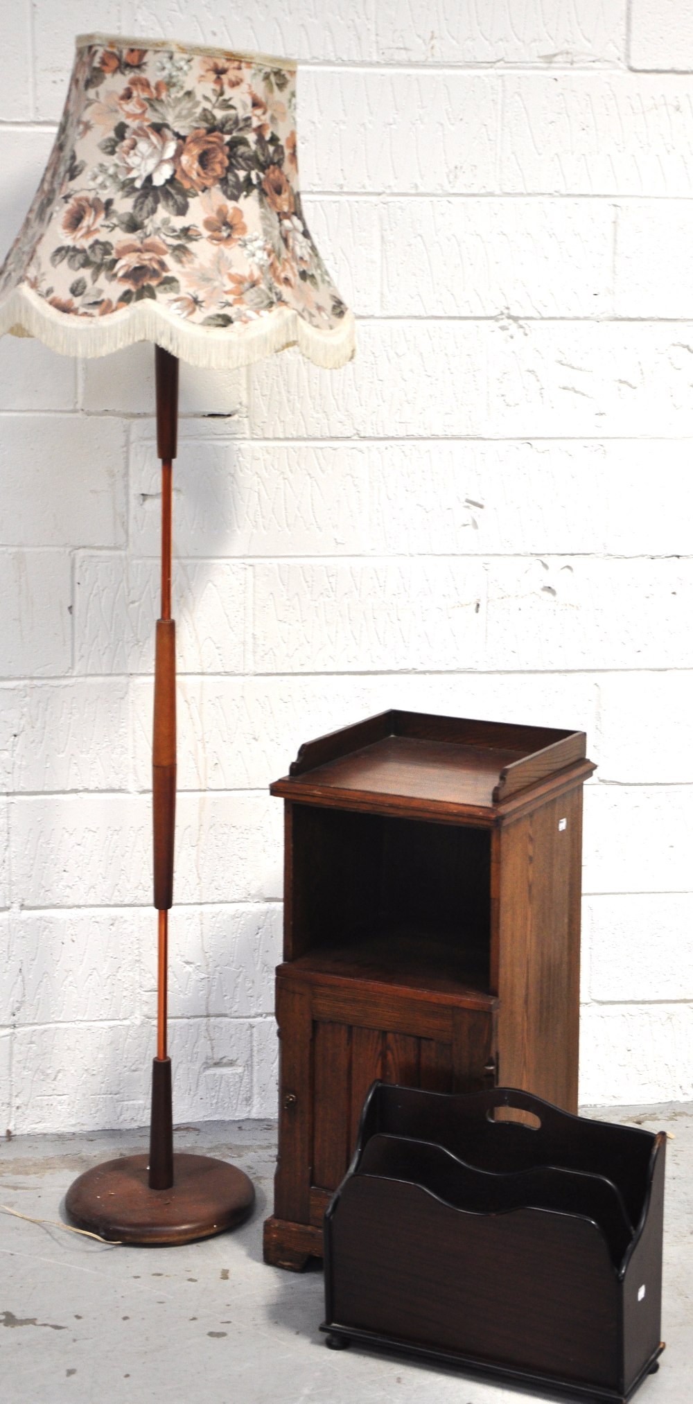 An early 20th century oak cabinet with open section above cupboard with single door bearing