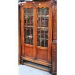 A mid 20th century oak part glazed two door book case on square section legs and stretchers, 180 x