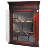A reproduction mahogany flat fronted hanging corner cupboard with fretwork decorated frieze and