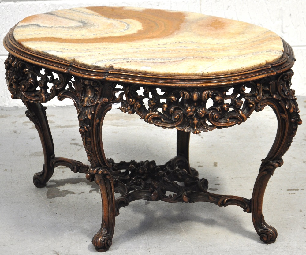 An ornate marble topped Italian carved walnut occasional table, the shaped inset top above foliate